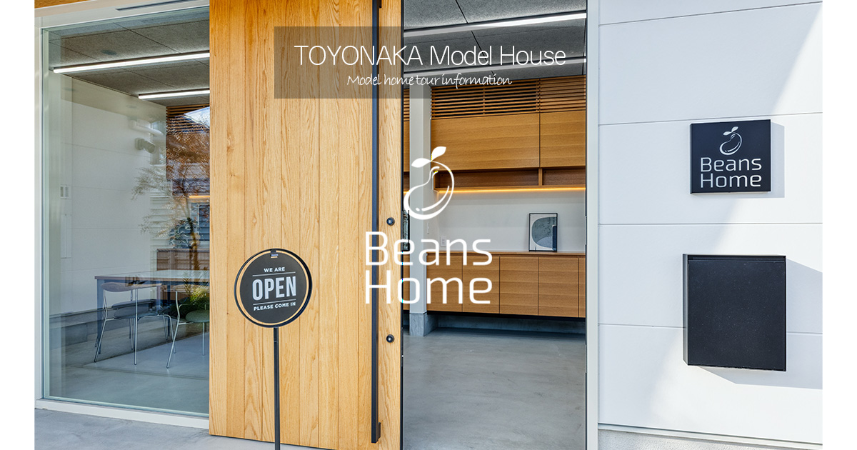 BeansHome豊中モデルハウスの外観。木目の美しい大きな扉が開かれ、室内には洗練された造作家具が見える。手前には「OPEN」の看板があり、ポップアップイベントの会場としての開放的な雰囲気を表現している。